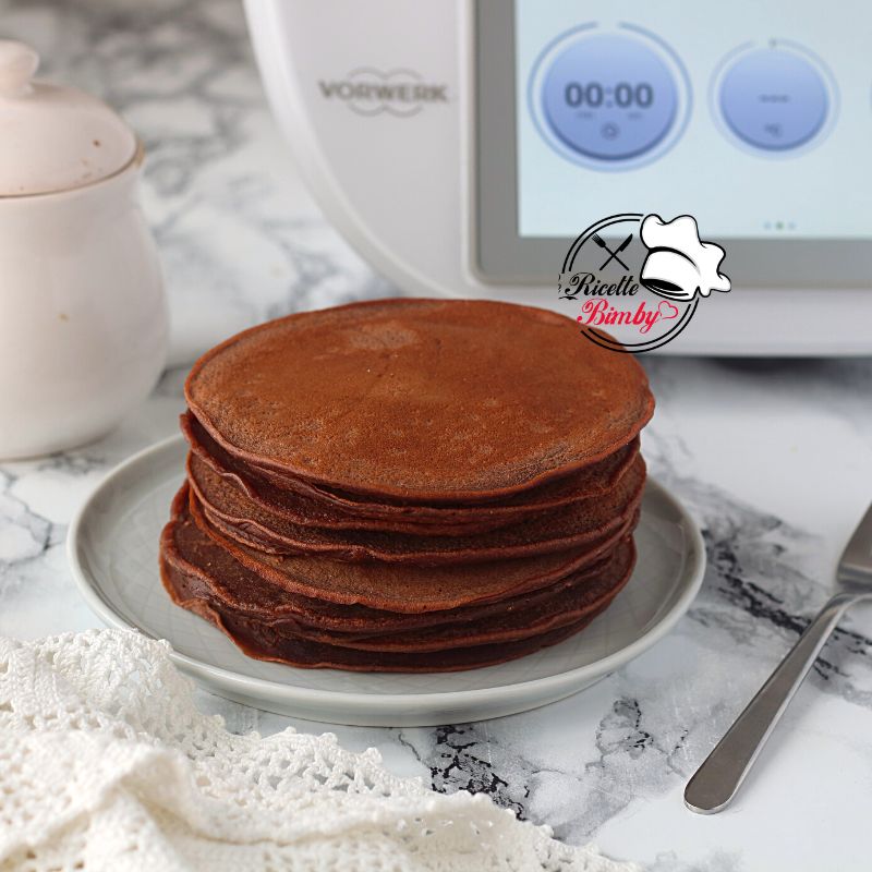 Per preparare i nostri Pancake al cacao mettete nel boccale tutti gli ingredienti e impastate per 1 minuto a velocità 5. Versate il composto preparato in una ciotola , coprite con pellicola trasparente e fate riposare 30 minuti in frigorifero. Al momento di essere serviti scaldate una padella antiaderente, ungete con del burro e versate al centro un mestolo di PASTELLA PER PANCAKE. Lasciate 1 minuto e quando iniziano a fare le bollicine girate dall'altra parte e fate stare per un altro minuto. PANCAKE AL CACAO BIMBY