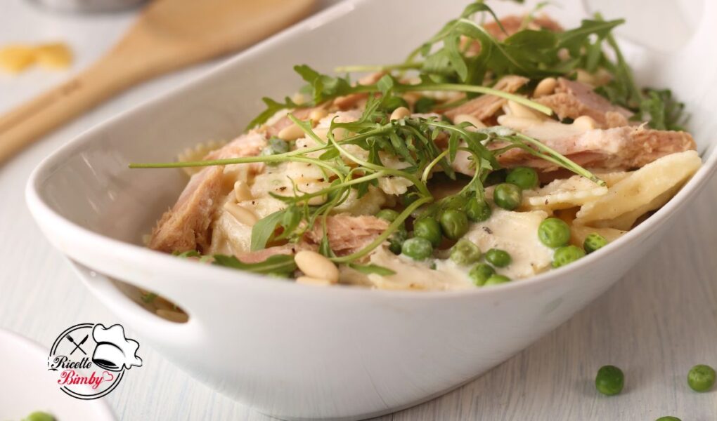 PASTA FREDDA AL TONNO CON PISELLI E RUCOLA BIMBY Questo fresco e sfizioso primo piatto è ottimo per un pasto leggero o per arricchire il buffet degli ospiti. Un piatto ricco e facile da preparare grazie al nostro Bimby per una pasta perfetta e un condimento delizioso. Con un delizioso condimento perfetto anche per altri tipi di piatti da non perdere!!! Perfetta anche per i più piccoli e per essere preparata in anticipo e portata al sacco. PASTA FREDDA AL TONNO CON PISELLI E RUCOLA BIMBY INGREDIENTI 1200 g di acqua 1 cucchiaino colmo di dado per brodo vegetale o 1 dado per brodo vegetale (dose per 0,5 l) 20 g di pinoli sgusciati (vedere varianti) 320 g di pasta secca tipo farfalle 5 g di olio extravergine di oliva + q.b. 250 g di piselli verdi, freschi o surgelati 100 g di Parmigiano Reggiano, a pezzi 300 g di tonno all'olio di oliva sgocciolato Per il condimento 50 g parmigiano a cubetti 40 g di cipolla 1 spicchio di aglio 30 g di olio extravergine di oliva 10 g di miele 30 g di aceto 1 cucchiaino di sale ½ - ¾ di cucchiaino di pepe nero macinato PROCEDIMENTO Mettere nel boccale l'acqua e il dado e scaldare per 10 minuti VAROMA velocità 1. Intanto tostare i pinoli sul fuoco in una padella antiaderente fino a doratura. Mettere da parte a raffreddare una volta pronti. Quando l'acqua nel boccale bolle mettere la pasta e l'olio di oliva. Posizionare sopra il recipiente del Varoma con il vassoio e sistemare i piselli all'interno. Posizionare sopra il Varoma e impostare il tempo di cottura della pasta VAROMA velocità 1. Una volta pronti pasta e piselli togliere i piselli dal contenitore del Varoma e metterli in un insalatiera. Scolare la pasta usando il recipiente del Varoma conservando 100 g di acqua in una ciotola e mettendo la pasta con un cucchiaio di olio a raffreddare con i piselli. Potete anche prepararli in anticipo e conservarli ben richiusi in frigorifero. Per il condimento e al momento di servire o condire la pasta Nel boccale pulito mettere il Parmigiano e tritare per 10 secondi a velocità 10. Portare sul fondo con la spatola. Aggiungere nel boccale del Bimby l'aglio e le cipolla, tritare per 2 secondi a velocità 7. Riunire sul fondo con la spatola. Poi aggiungere l'acqua di cottura della pasta, l'olio di oliva, il miele, l'aceto, il sale e il pepe. Mescolare per 10 secondi a velocità 10. Una volta pronti tutti gli elementi condire la nostra pasta amalgamare ai piselli, aggiungendo la rucola, il tonno ben scolato e il condimento preparato e arricchire con i pinoli tostati e una spolverata di Parmigiano al momento. Buon appetito! Potete seguirci anche su Telegram ⇒ LE RICETTE BIMBY o su INSTAGRAM Se volete RICEVERE LE MIE NUOVE RICETTE OGNI GIORNO IN ANTEPRIMA SU WHATSAPP salvate il mio numero di telefono 3886946238, memorizzatelo come LE RICETTE BIMBY e scrivetemi su whatsapp il vostro NOME e COGNOME con testo RICETTE BIMBY DEL GIORNO e sarò lieta di inviarvele! Se questa ricetta vi è piaciuta continuate a seguirmi e se vi va mettete mi piace sulla mia pagina Facebook >> Ricette con il Bimby facili clicca qua per tornare alla HOMEPAGE